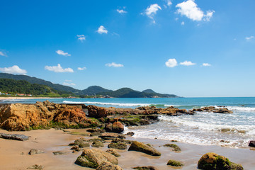 Mar azul esverdeado e pedras de praia tropical< itapema