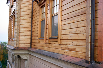 Facade of a wooden house. Window in the wall of a house, outside view.