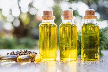 Bottle of CBD hemp oil, seeds in wooden spoons and tablets extracted from hemp Alternative medicine concepts Natural herbs used to treat diseases. Bio-marijuana and ecology.