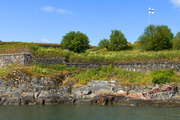 Fototapeta na wymiar Suomenlinna (Sveaborg) fortress is UNESCO World Heritage Site. Landscape with flag