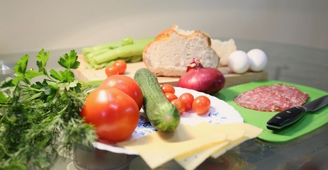 Still life from fresh vegetables and bread: celery, tomatoes, greens, cabbages.