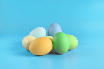 Several easter eggs on blue surface. Colorful easter eggs decoration. Copy space for text.