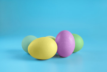 Several easter eggs on blue surface. Colorful easter eggs decoration. Copy space for text.