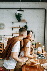 Beautiful couple preparing food. Love story in the interior Studio. Happy and laughing people. Breakfast is served in the kitchen.
