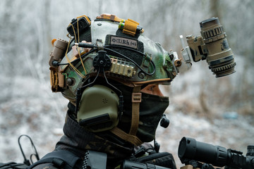 Closeup head of military man in helmet, uniform and mast. Soldier in the winter forest. Vertical photo.