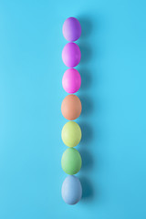 Seven easter eggs on blue surface. Colorful easter eggs decoration. Flat lay, top view. with copy space for text