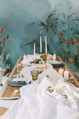Autumn decor with fabric and dried flowers. Wedding in the style of fine art. Wedding table decor with candles.