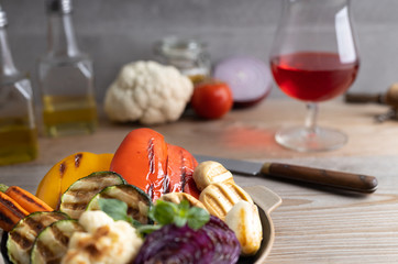 Fresh organic grilled vegetables bell pepper,mushrooms,broccoli,cauliflower,carrots seasoned with herbs on a round plate.