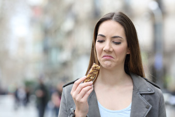 Disgusted woman looking at snack bar on city street