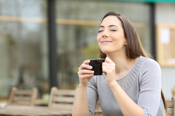 Girl breathing holding a cup of coffee on a terrace