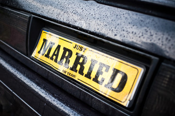 Just Married car plate. Rainy wedding day. Bad weather water drops.