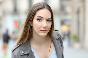 Suspicious woman looking at camera on city street