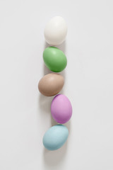 Five easter eggs lie in a straight line. White background for lettering and design. Copy space for your text