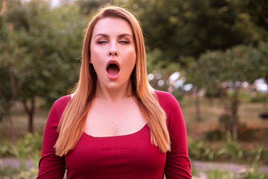 Woman imitate orgasmic face. She wear casual but sexy outfit and standing in park. Summer evening portrait with space for hext