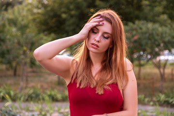 Fototapeta premium Caucasian beautiful woman in casual outfit cry, make unhappy emotions. She standing in park, outdoor. Summer evening weather. Space for text