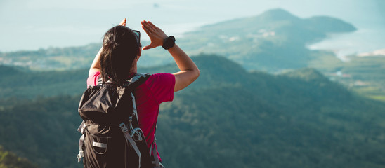 Young woman hiker yelling at mountain top