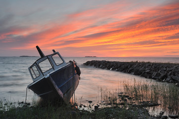 Fototapeta na wymiar Moored fishing boat on shore at sunset, Lake Vänern, Sweden, Europe