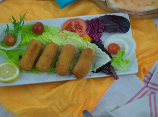 Chicken croquettes on lettuce on white tray