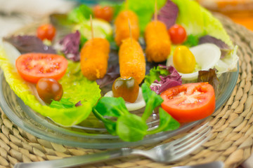 Chicken croquettes with chopped salad with chopsticks as a lid on glass dish to eat