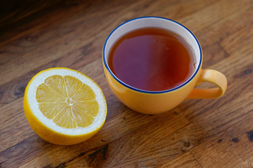 cup of tea and sliced lemon on a wooden table