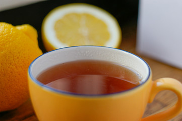 cup of tea and sliced lemon on a wooden table