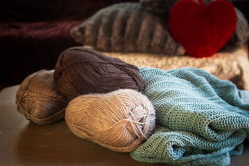 Cosy still life of room with balls of wool and cozy jumper on table