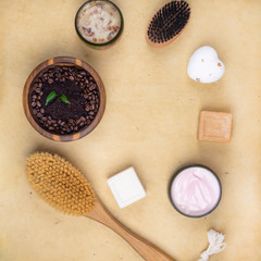 Obraz na płótnie Canvas cream lotion, scrub, soap, body brush on wooden surface