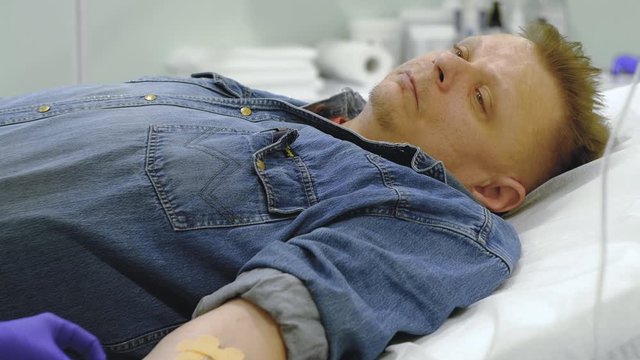 nurse fixes infusion needle to patients hand