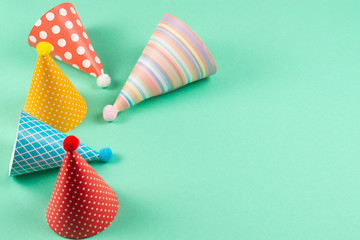 Obraz premium Colorful birthday caps on mint background.