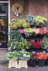 Flower store or cafe entrance decorated with flowers, beautiful flower shop in Europe