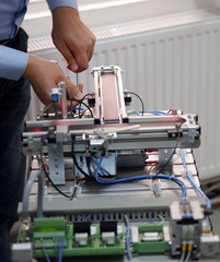 Close-up of male technician repairing automation system by allen key.	