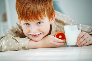 A child drinks milk with cookies.