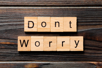 Don't worry word written on wood block. Don't worry text on wooden table for your desing, Top view...