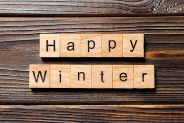 Happy winter word written on wood block. Happy winter text on wooden table for your desing, concept