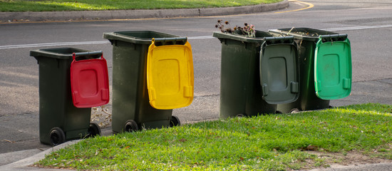 Australian garbage wheelie bins with colourful lids for recycling household waste and green garden...