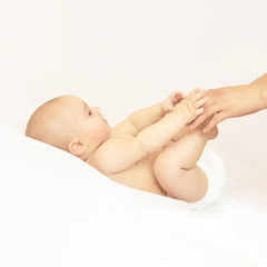 Newborn boy, mother hand. Infant mom massage. funny children change diaper. Home napkin.
