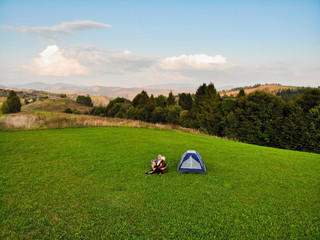 Aerial view of love couple of hikers spend time together away from city bustle by sunrise in...
