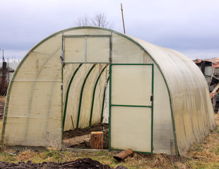 greenhouse made of polypropylene in the garden. early spring.