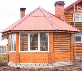 yellow enclosed gazebo with red roof and chimney from the fireplace