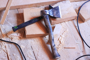 forged axe on the wooden floor. tools at the construction site