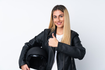 Young Uruguayan woman with a motorcycle helmet over isolated white background giving a thumbs up gesture