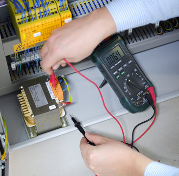 Close up to the multimeter. Electrician use Multimeter to measure voltage and checking on transformer. Maintenance and service job.