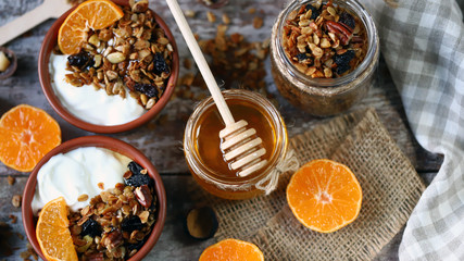 Healthy breakfast or dessert. Yogurt with granola and tangerine. Homemade granola. Honey. Flat lay.