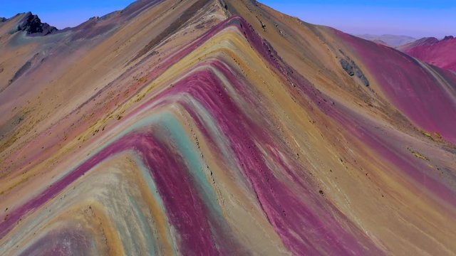 Close aerial views to Rainbow Mountain Peak at Vinicunca Valley. Spectacular Mountain full of different colors: orange, red, yellow, greens