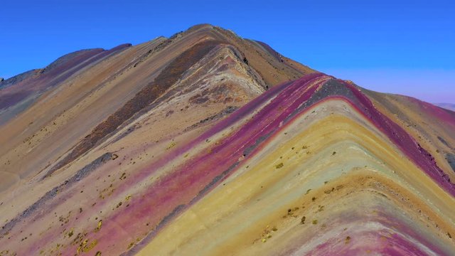 Aerial view of Rainbow Mountain from above. Colourful landscape with reddish tones. Vinicunca Valley, Cusco Region, Peru