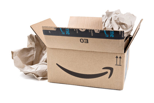 Amazon Prime cardboard box open with wrapping paper on white background.