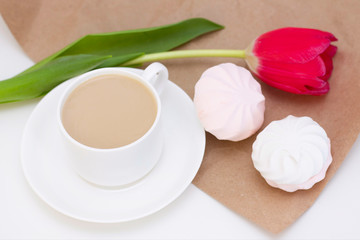 Fototapeta na wymiar marshmallows, tea or coffee with milk and a tulip flower. on a light background. Romantic spring morning. delicate breakfast, breakfast in bed. for the beloved. Surprise.