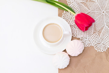 marshmallows, tea or coffee with milk and a tulip flower. on a light background. Romantic spring morning. delicate breakfast, breakfast in bed. for the beloved. Surprise.