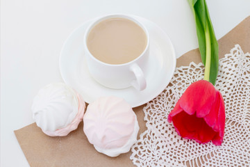 marshmallows, tea or coffee with milk and a tulip flower. on a light background. Romantic spring morning. delicate breakfast, breakfast in bed. for the beloved. Surprise.