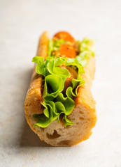 Tasty fresh hot dogs with grilled sausage, french mystard and fresh salad leaves on the rustic...